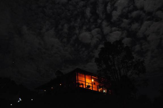 Na noite escura, na casa iluminada, leitura no computador, em Curitiba, no Paraná